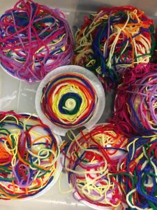 multicolored yarn on plastic bowls