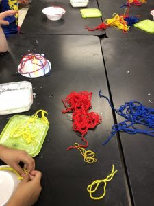 piles of red, blue, yellow yarn on table