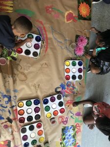 small children painting on brown paper