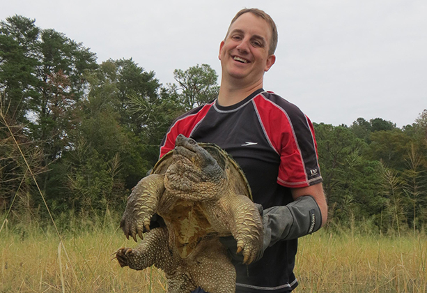 Ben Colteaux, P h. D., holds a snapping turtle.