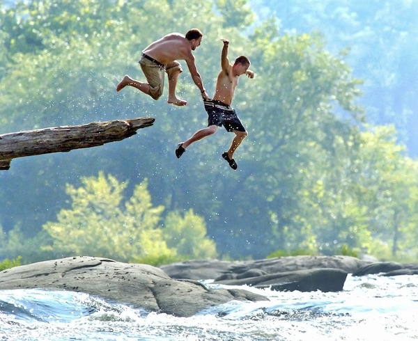 Two men jumping into the James River