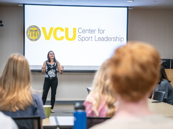 Carrie LeCrom lecturing class in front of board that reads "VCU Center for Sport Leadership"