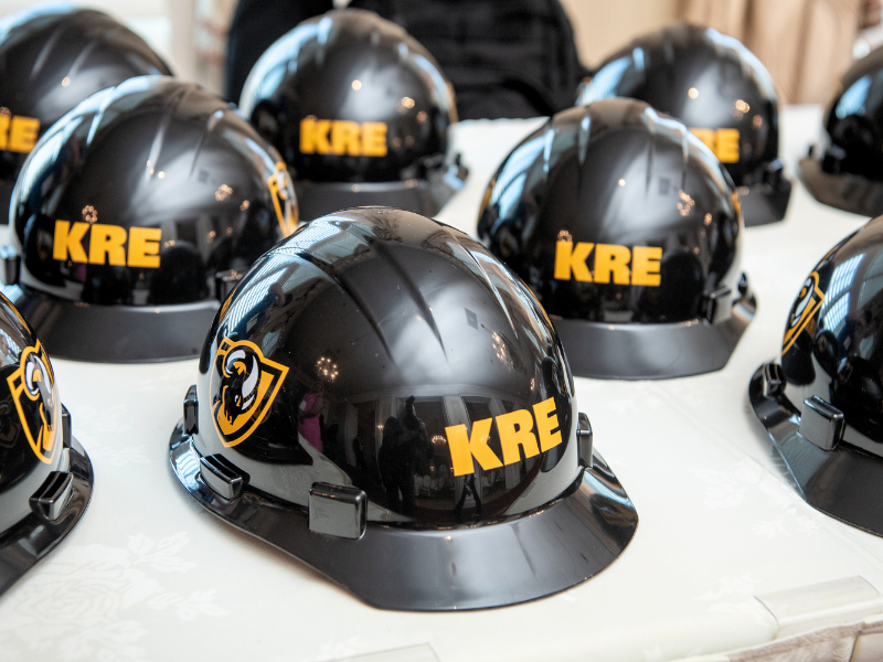 Black Hard hats with "KRE" lettering in gold