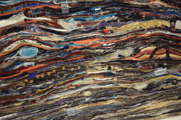Multi-colored piece of textile art created from many layers of fabric.