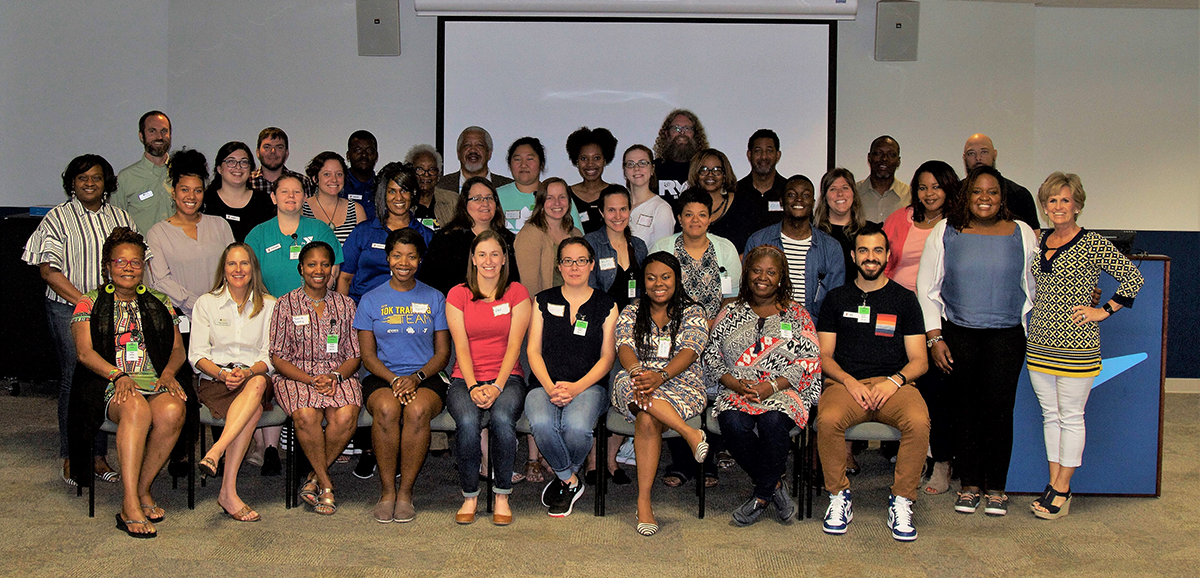 A large group of youth development professionals pose together.