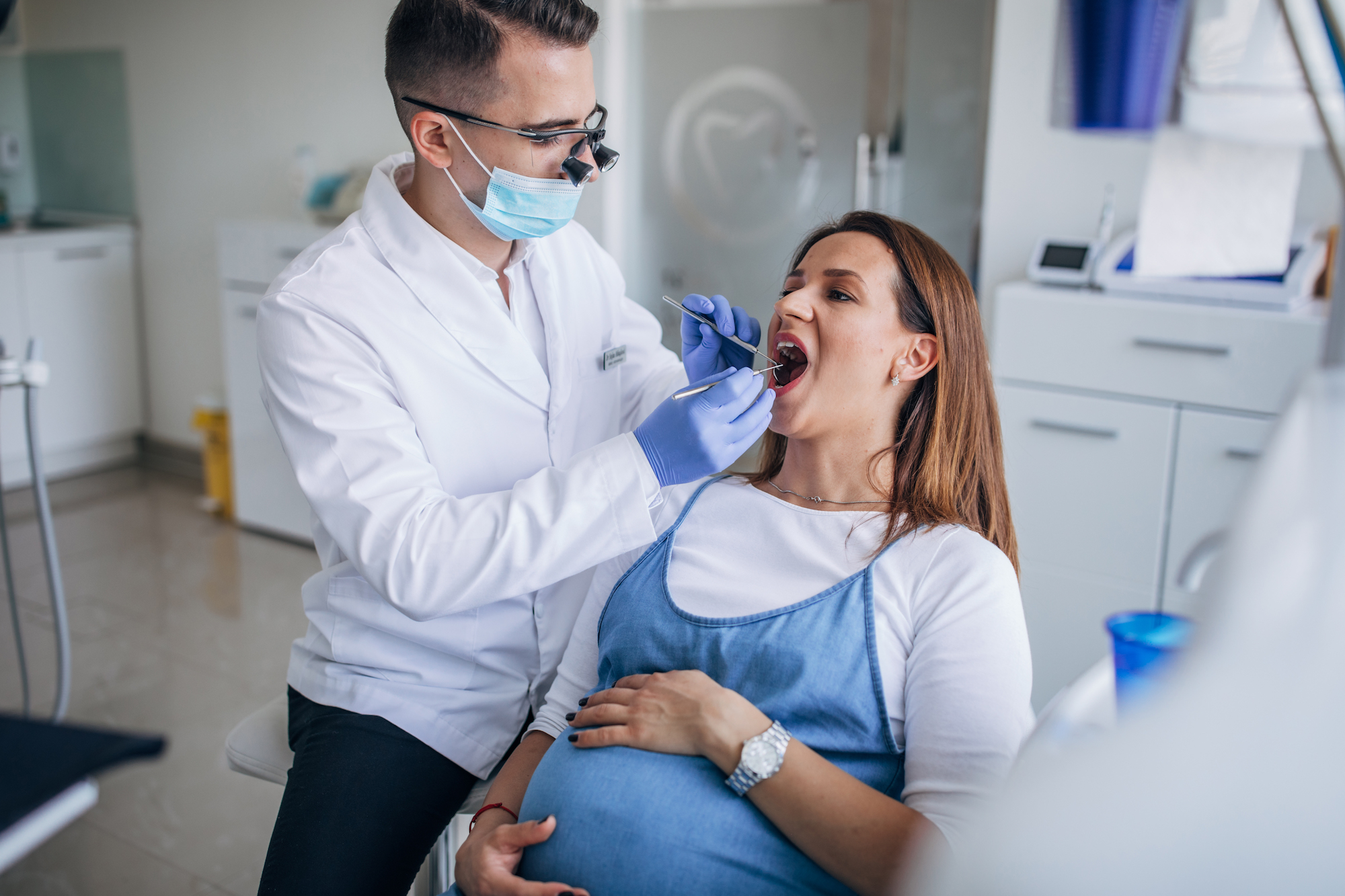 Pregnant woman having her mouth examined by a dentist.