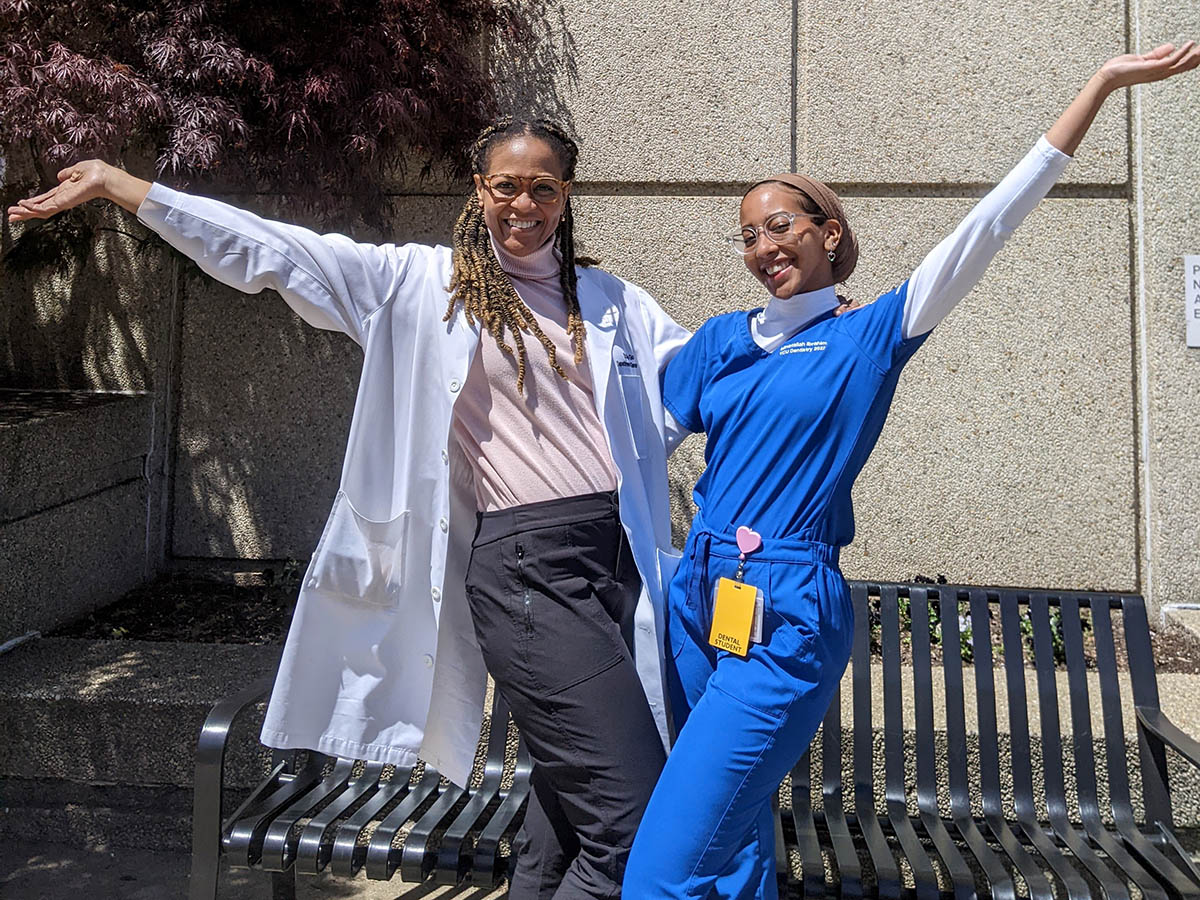 Mina Ibrahim and Dr. Susie Goolsby pose next to each other outside of the entrance to VCU School of Dentistry. 