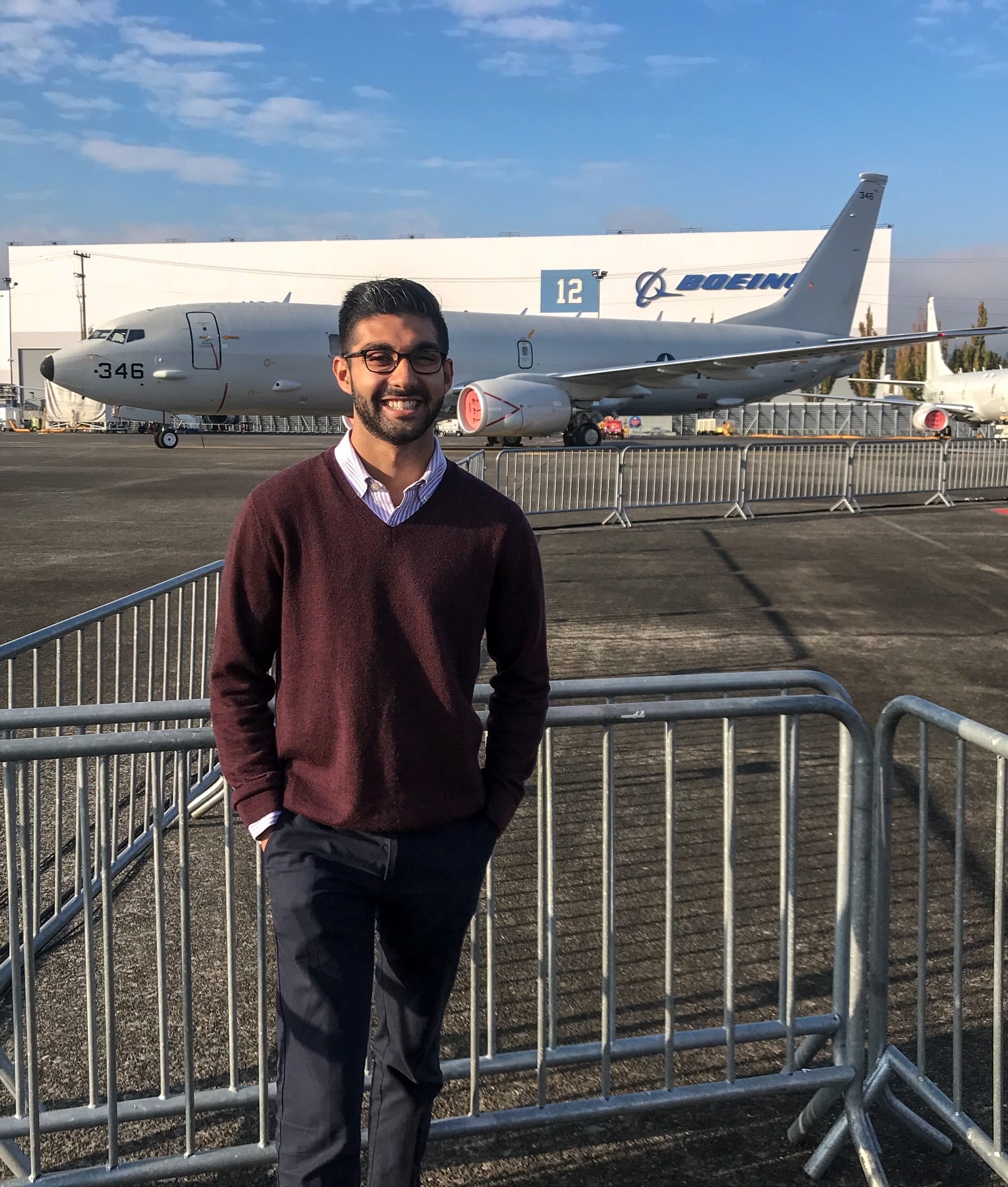 Arzan Dotivala stands in front of a passenger jet outside of the Boeing Company offices in Seattle.