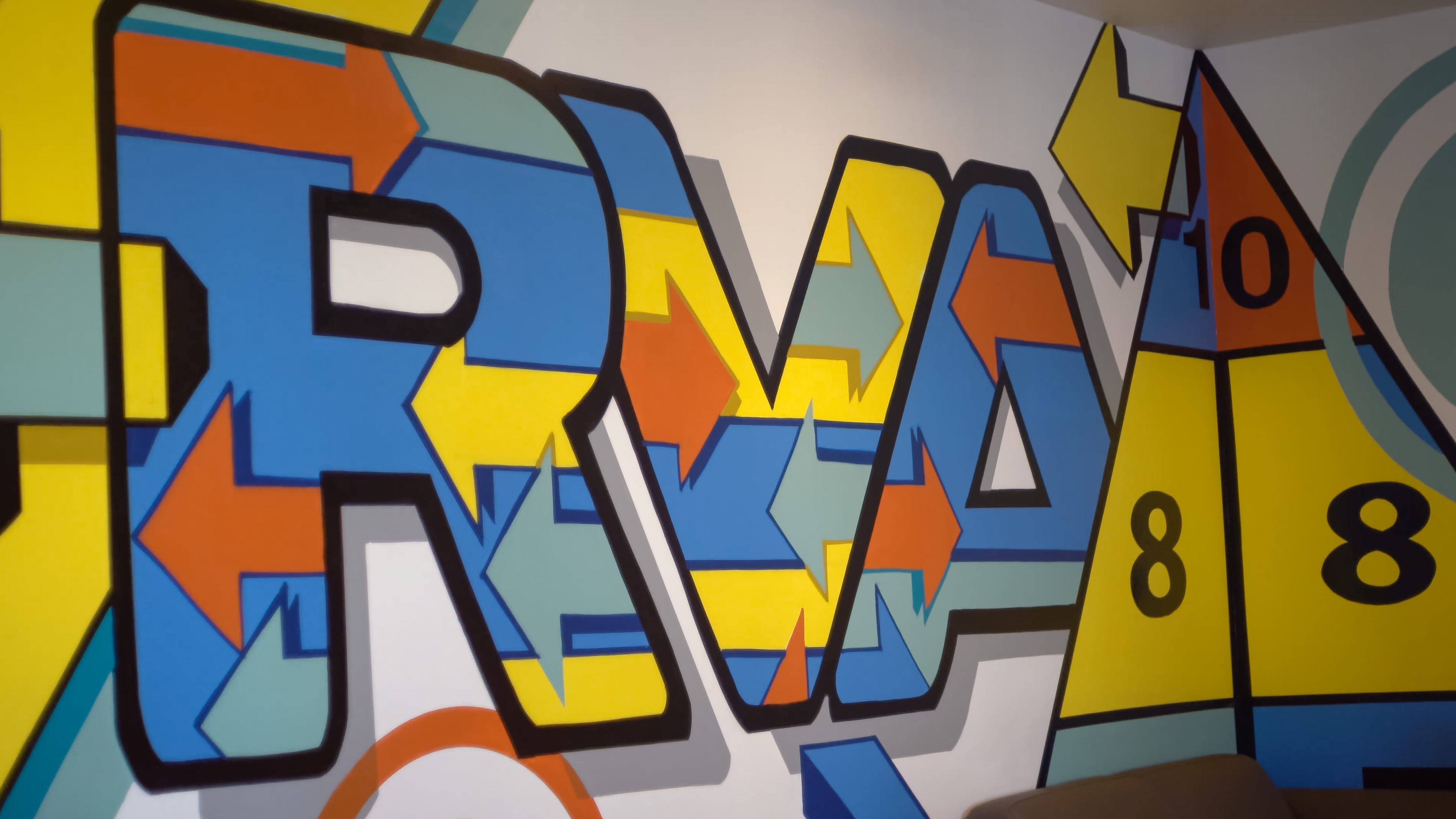 A wall mural that says "RVA" designed with multicolored arrows.