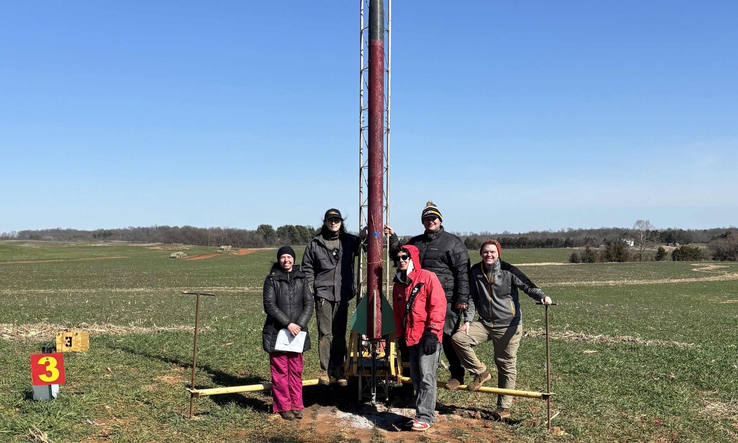 Ram Rocketry students standing next to a large rocket