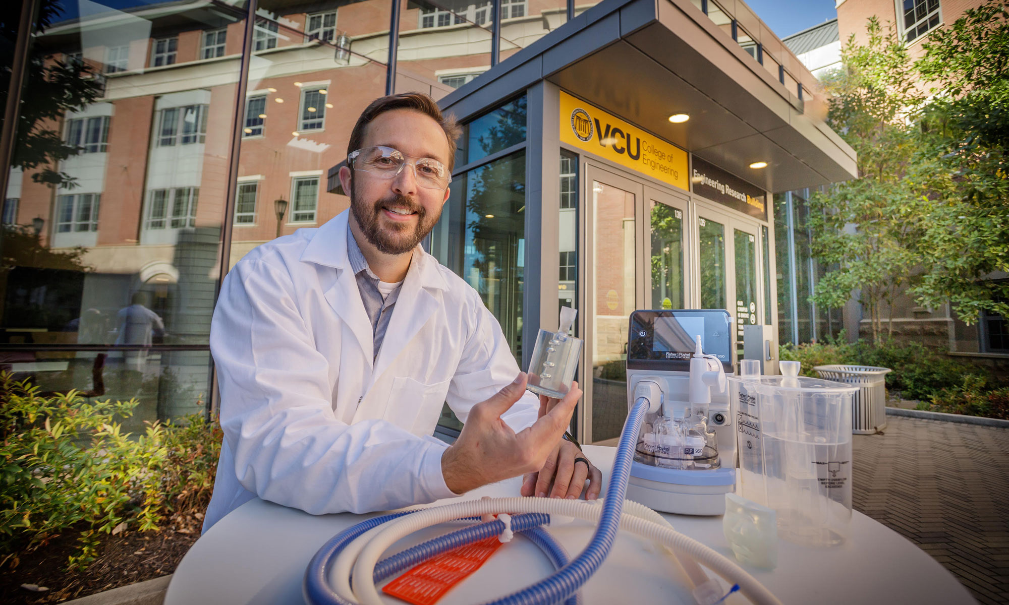 Casey Grey outside of the Engineering Research Building holding a medical device