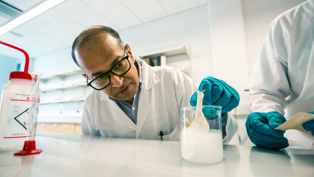 Arvind Agarwal, Ph.D., demonstrates the application of the polydimethylsiloxane boron nitride slurry to a fabric layer.