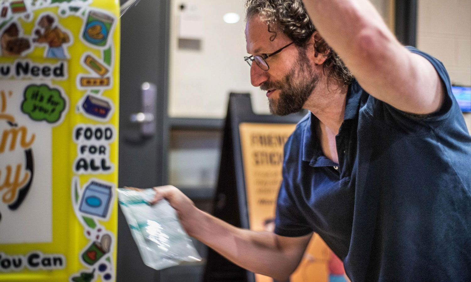John Jones, Ph.D., an assistant professor in the School of Life Sciences and Sustainability who established the Little Ram Pantries project, stocks a box in Cary Street Gym.