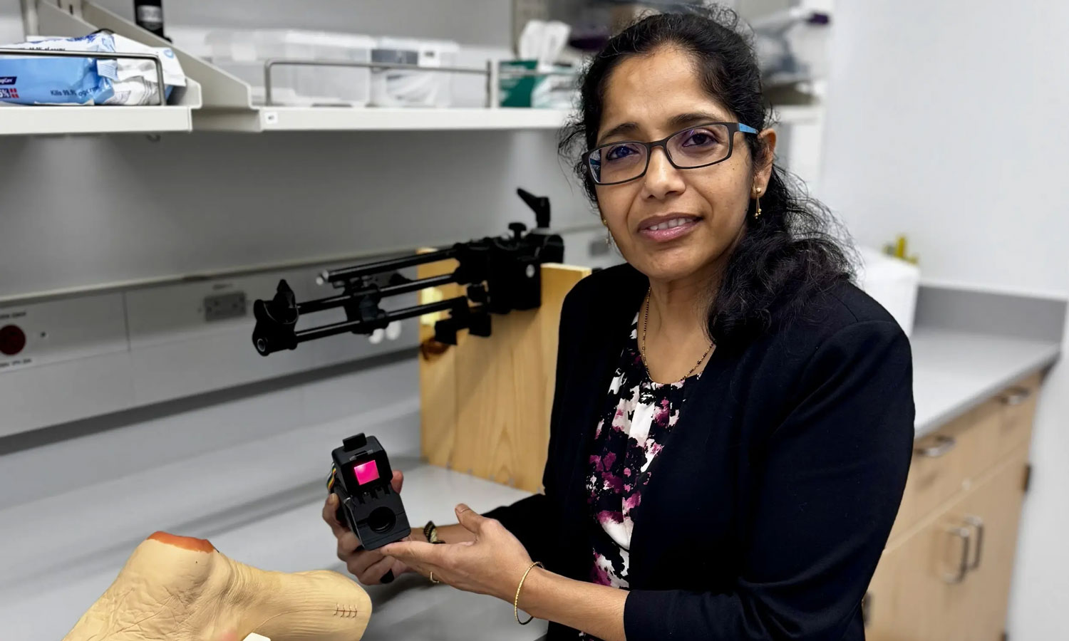 Anuradha Godavarty, Ph.D., with the NIROS scanner in her Optical Imaging Laboratory at VCU. The near-infrared device measures how much oxygen-rich blood reaches tissue just beneath the skin without using injected dyes or touching the patient.