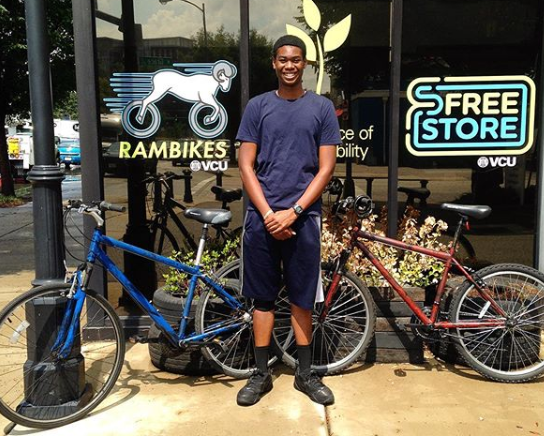A student stands in front of the Rambikes and Free Store storefronts on VCU's campus.