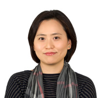 A headshot of Dr. Youngmi Kim with a short black bob, a grey and black striped top and scarf.