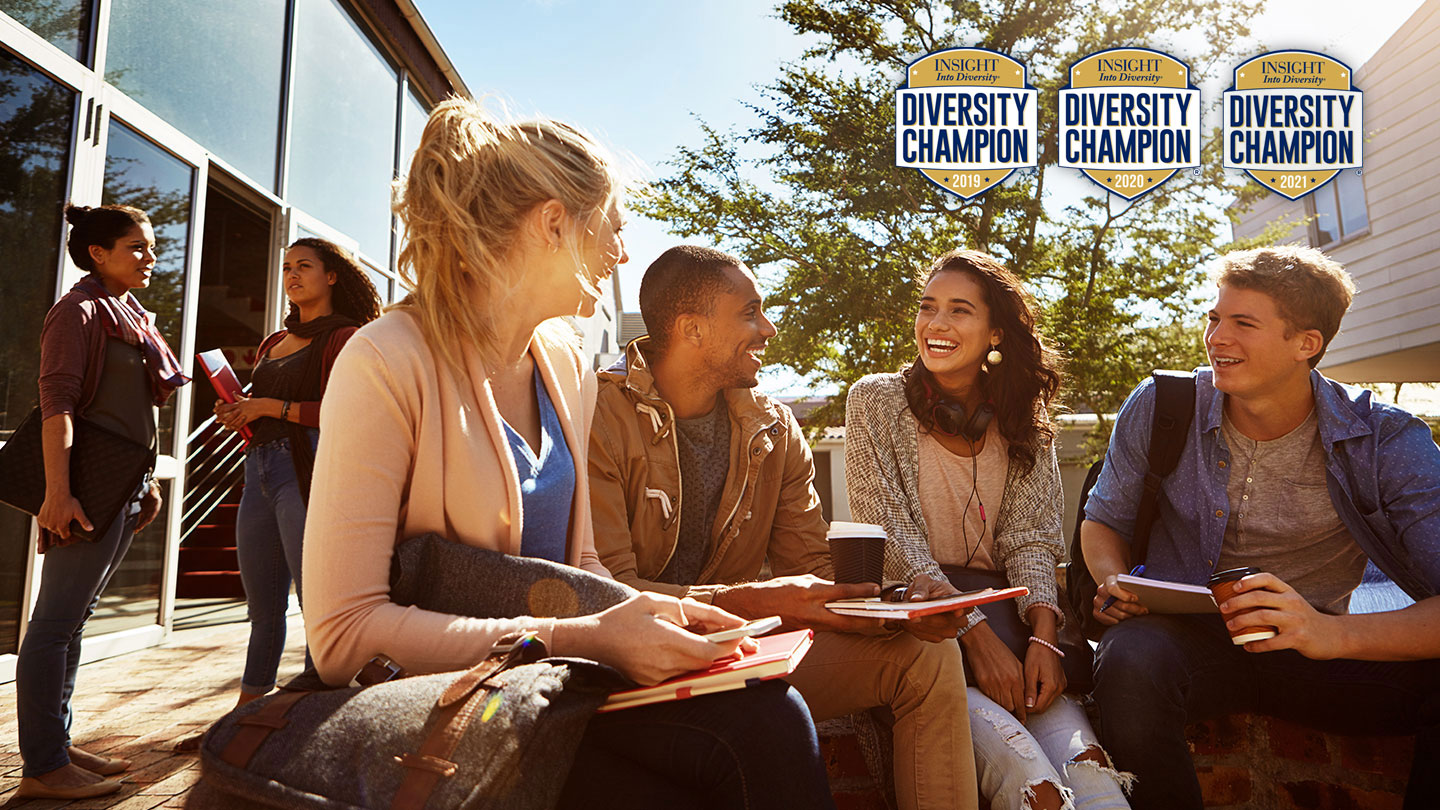 Group of students sitting outside talking; superimposed are the Diversity Champion logos from 2019-2021