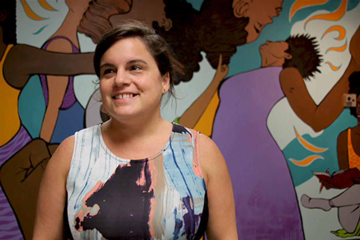 Liz Canfield poses in front of a colorful mural.