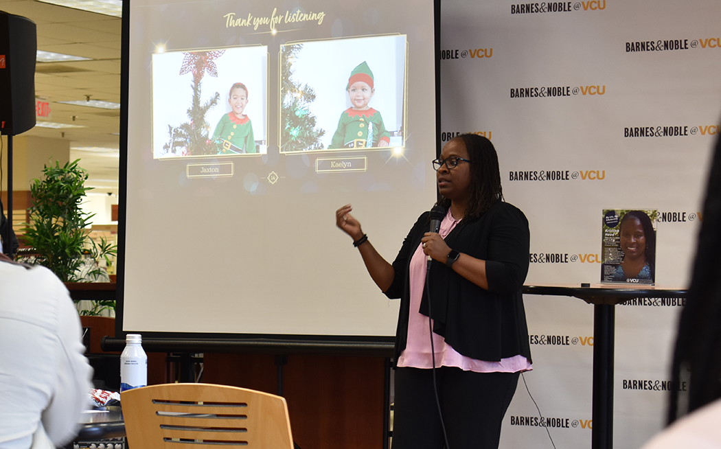 Kristina Hood speaks at the VCU Barnes & Noble. On the screen behind her is a slide that says "Thank you for listening," with images of her children wearing festive elf outfits.