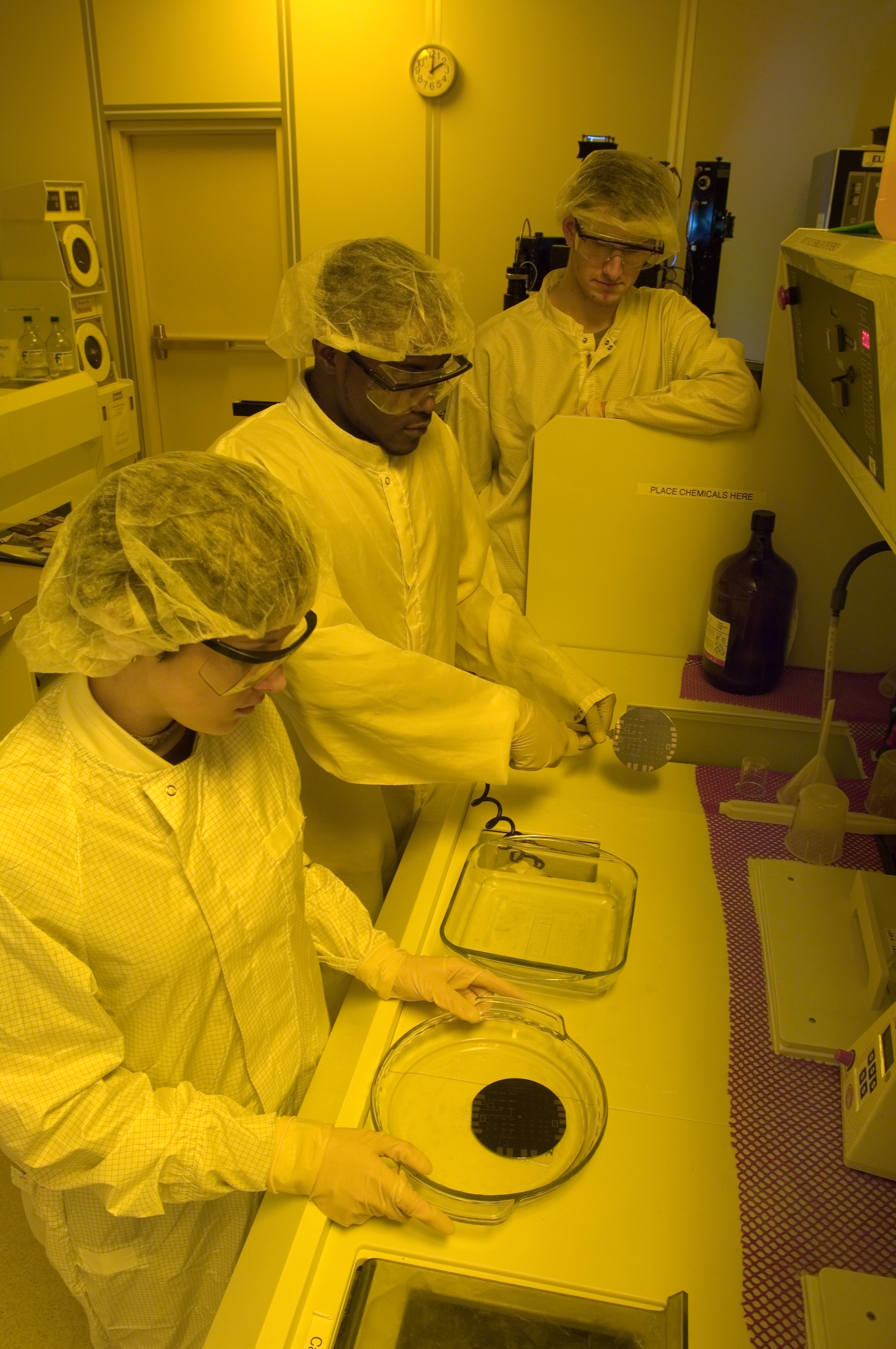 Researchers with the C. Kenneth and Dianne Wright Center for Clinical and Translational Research clad in protective gear, examining a lab specimen.