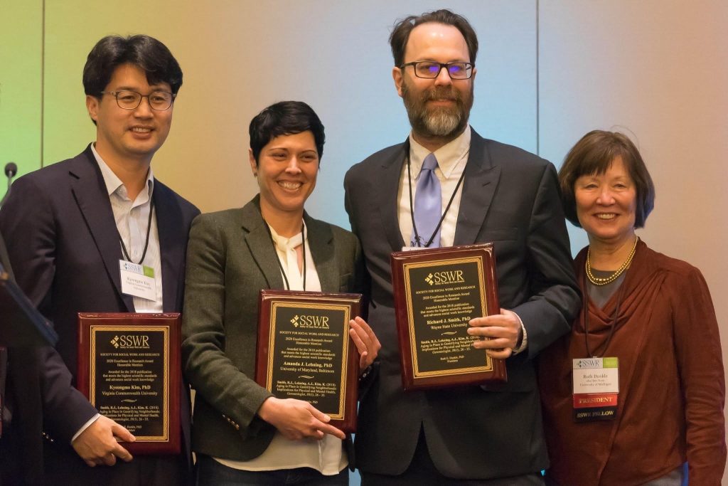 Standing and holding their award plaques are VCU social work assistant professor Kyeongmo Kim; Amanda J. Lehning, University of Maryland, Baltimore; and Richard J. Smith, Wayne State University. They are joined by Ruth E. Dunkle, University of Michigan and SSWR president. 