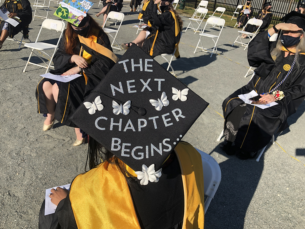 A graduates' mortarboard reads: "The next chapter begins ..." and is decorated with white butterflies. 