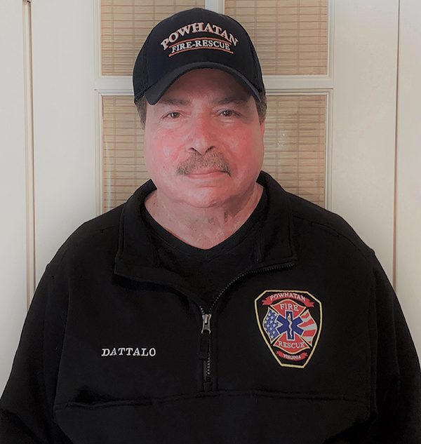 Pat Dattalo in his Powhatan Fire and Rescue black hat and jacket, displaying his emergency medical technician badge
