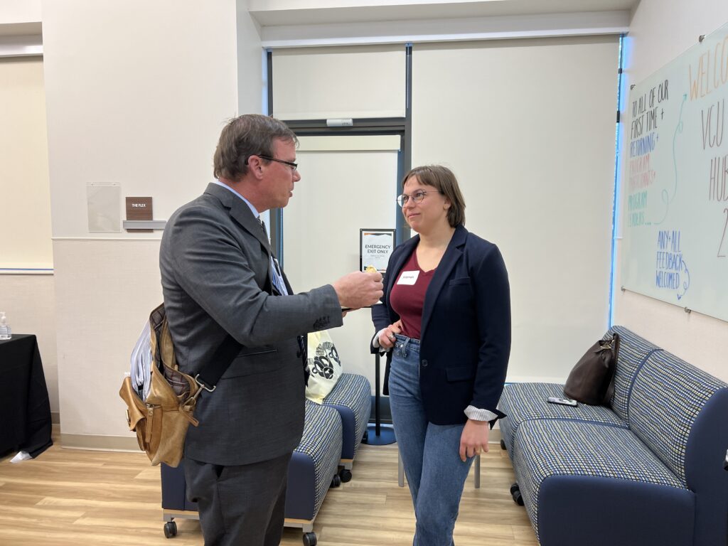 Interim Dean Gary Cuddeback stands and talks with a student