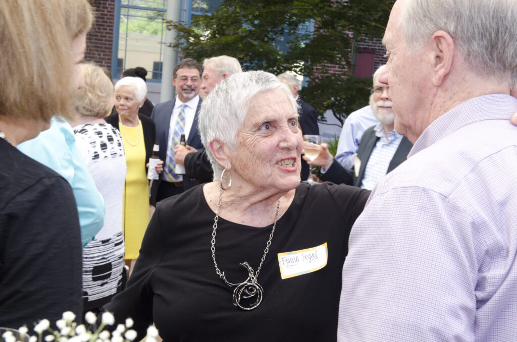 Flossie Segal smiles as she talks and hugs a friend during a School of Social Work event.