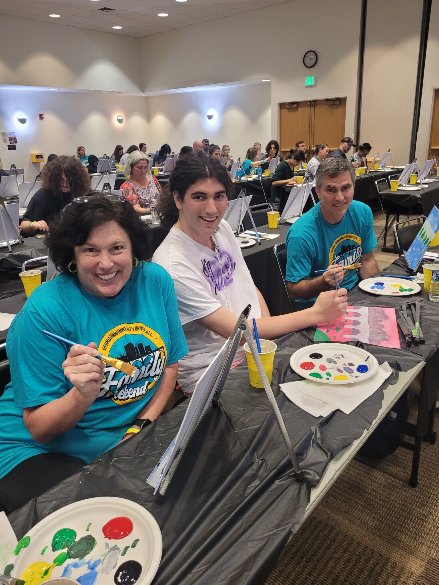 Parents and their student enjoy the painting program during family weekend.