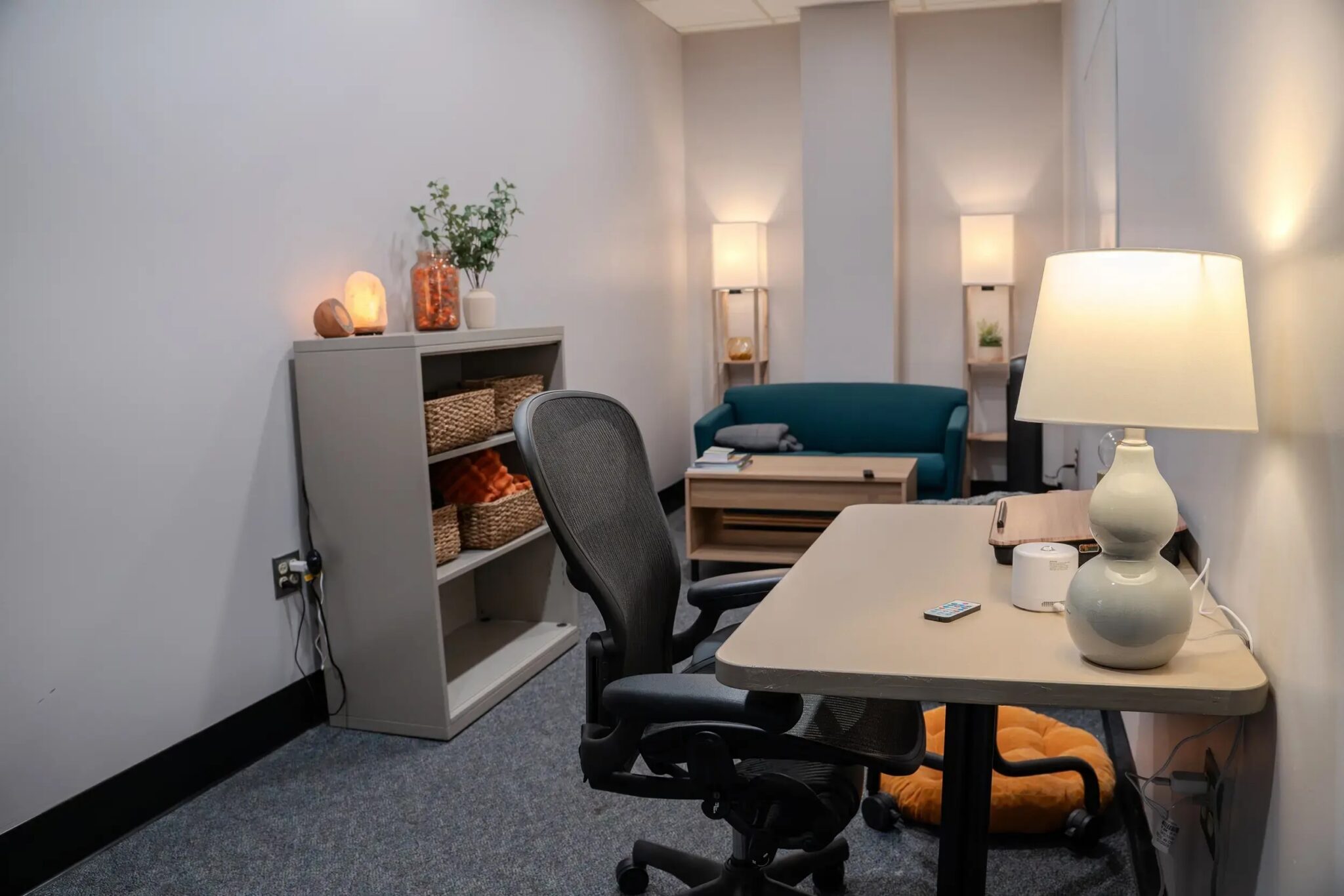 Sensory room set up with a desk, soft lighting, sound panels to keep quiet, and comfortable chair and carpet