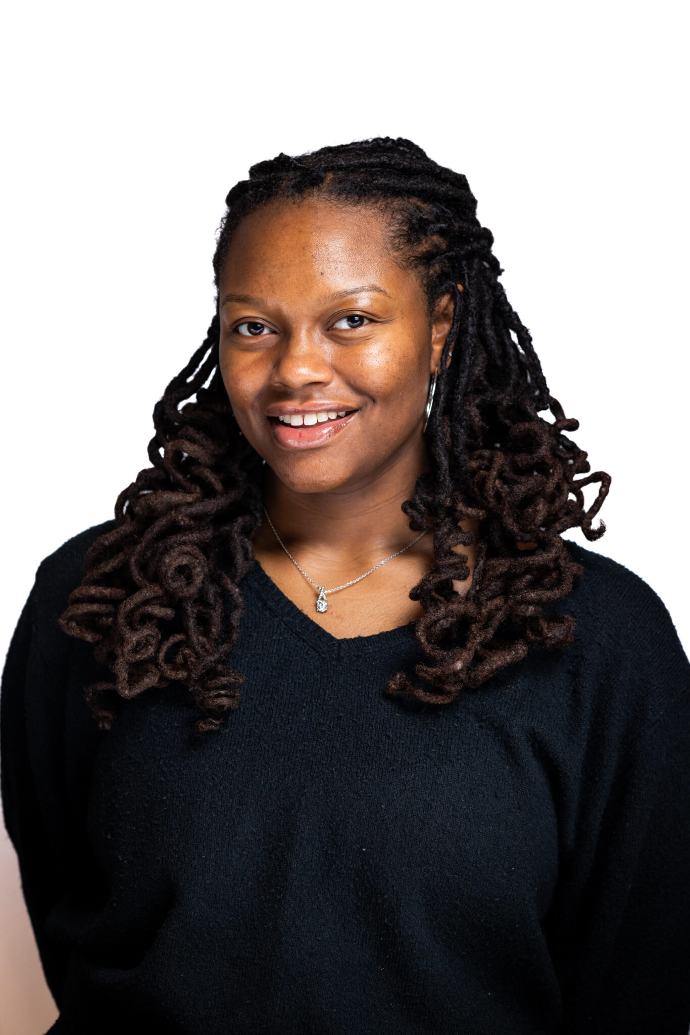 Headshot of Inayah smiling for the camera in a black shirt