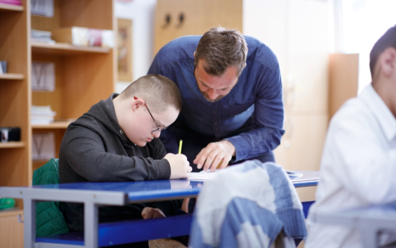 Image of teacher helping student in classroom