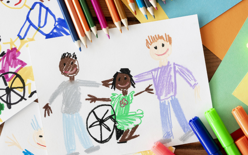 Children's' drawing of three smiling kids. One child is in a wheelchair.