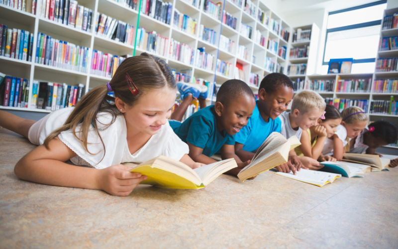 Photo of a group of young children reading in a library