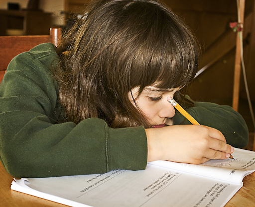 Image of a young girl filling out a workbook