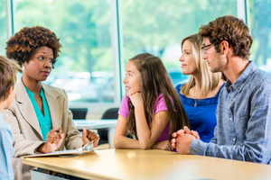 Photo of a teacher and students talking