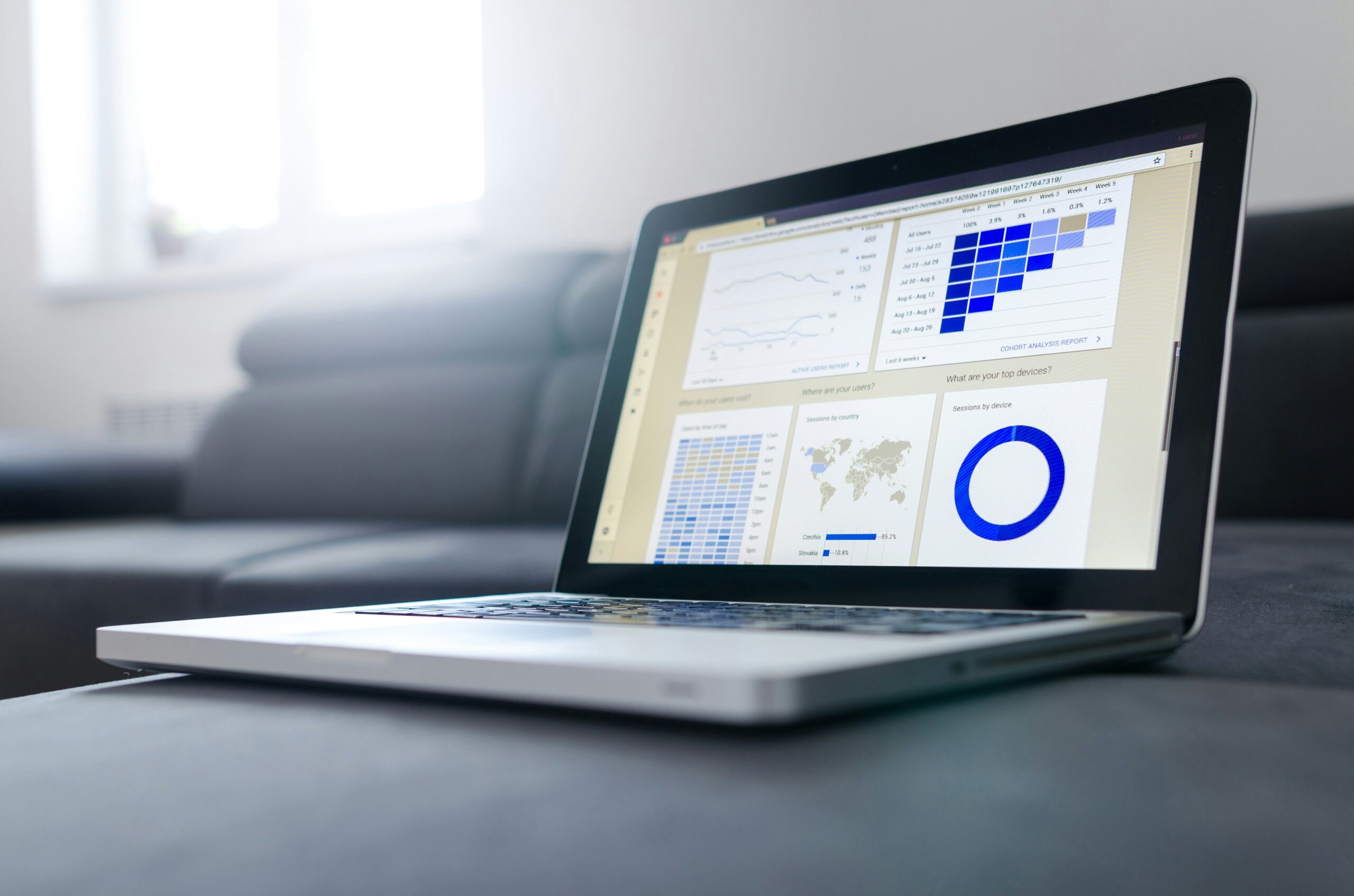 An open laptop shows blue data infographics