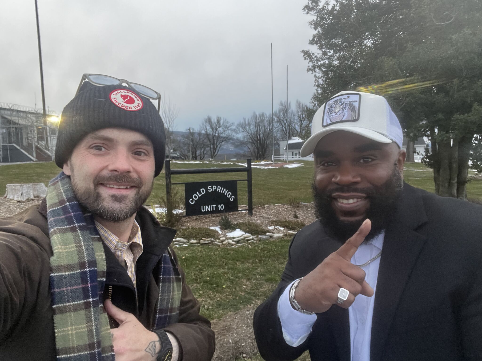 Matthew Britt and Azeem Majeed stand in front of a sign
